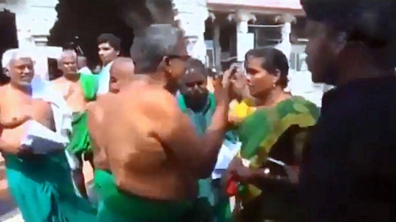 The scuffle ensued when the Nellaiyammal objected to Ayyakannu distributing pamphlets and waved her slippers at him, prompting the farmer leader to retaliate with verbal abuses. (Photo: Screengrab | ANI) The scuffle ensued when the Nellaiyammal objected to Ayyakannu distributing pamphlets and waved her slippers at him, prompting the farmer leader to retaliate with verbal abuses. (Photo: Screengrab | ANI)