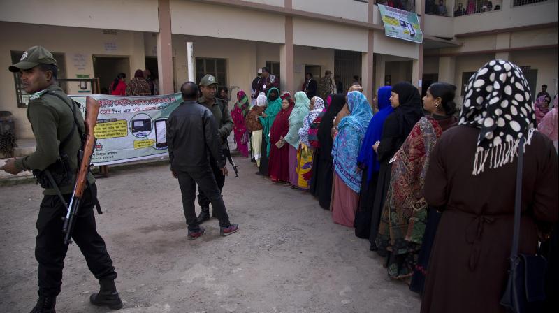 Bangladeshi security personnel stand guard as women line up to cast their votes outside a polling station in Dhaka on Dec 30. (Photo: AP) Bangladeshi security personnel stand guard as women line up to cast their votes outside a polling station in Dhaka on Dec 30. (Photo: AP)