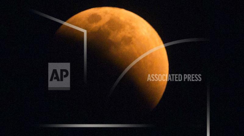 The moon turns a reddish hue as it passes through the earth's shadow during a lunar eclipse as seen in Gauhati, India. The moon turns a reddish hue as it passes through the earth's shadow during a lunar eclipse as seen in Gauhati, India.