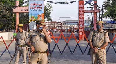 Police personnel stand guard to restrict entry into Sahibabad market, during the nationwide lockdown to curb the spread of coronavirus. PTI photo