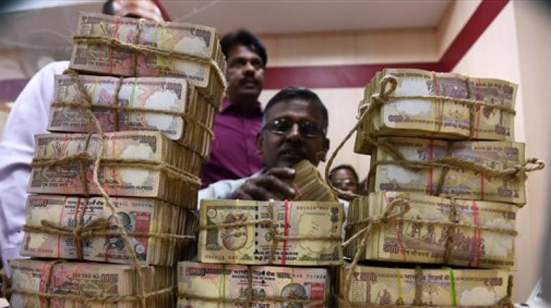 A Bank Employee counting the bundles of the received currency of old 1000 & 500 notes at cash counter. (Photo: PTI) A Bank Employee counting the bundles of the received currency of old 1000 & 500 notes at cash counter. (Photo: PTI)