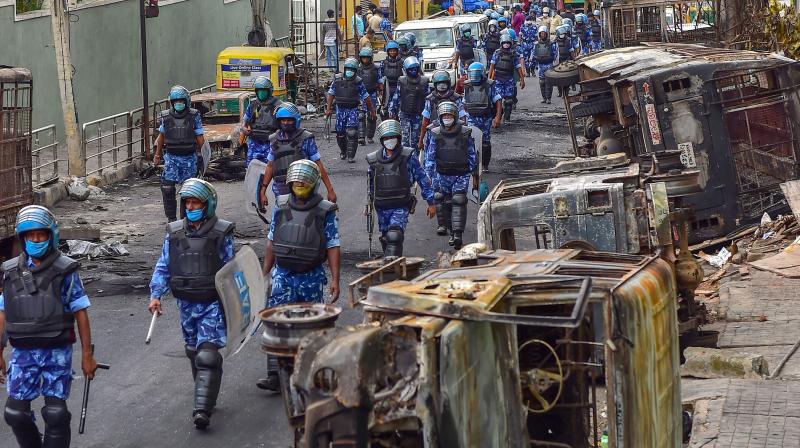 Rapid Action Force (RAF) personnel carry out a flag march in the riot-hit area after a mob went on a rampage on Tuesday over a social media post, allegedly posted by a Congress MLA's relative, in Bengaluru. PTI Photo Rapid Action Force (RAF) personnel carry out a flag march in the riot-hit area after a mob went on a rampage on Tuesday over a social media post, allegedly posted by a Congress MLA's relative, in Bengaluru. PTI Photo