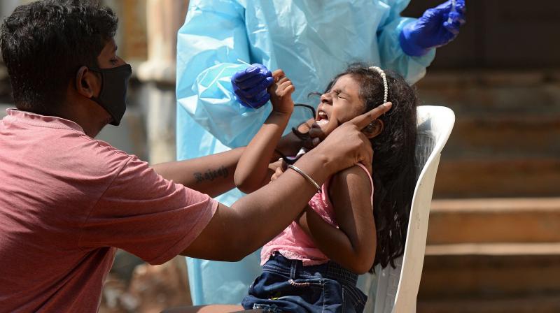 A girl reacts as a health worker wearing protective gear prepares to collect her swab sample to test for the Covid-19 coronavirus at sample collection centre in Hyderabad on October 29, 2020.(AFP) A girl reacts as a health worker wearing protective gear prepares to collect her swab sample to test for the Covid-19 coronavirus at sample collection centre in Hyderabad on October 29, 2020.(AFP)
