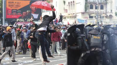 A protester tries to hurl a brick towards police trying block protesters from advancing towards the Presidential Palace during a rally in Jakarta, Indonesia, Thursday, Oct. 8, 2020. Thousands of enraged students and workers staged rallies across Indonesia on Thursday in opposition to a new law they say will cripple labor rights and harm the environment. (AP)