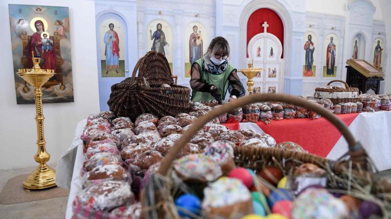 An Orthodox volunteer inspects traditional cakes and eggs before a blessing to be distributed to people in need, on the eve of the Orthodox Easter. AFP Photo