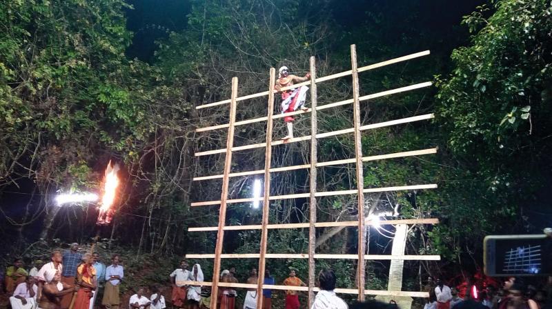 The Bhagavathi Thira climbs upon the wooden crossbar as part of the ritual dance Azhimuri Thira. The Bhagavathi Thira climbs upon the wooden crossbar as part of the ritual dance Azhimuri Thira.