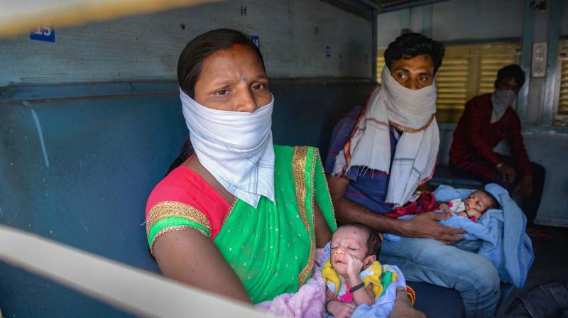 A migrant couple with their infant twins board a train to Jharkhand, during the ongoing COVID-19 nationwide lockdown, in Jalandhar. PTI Photo