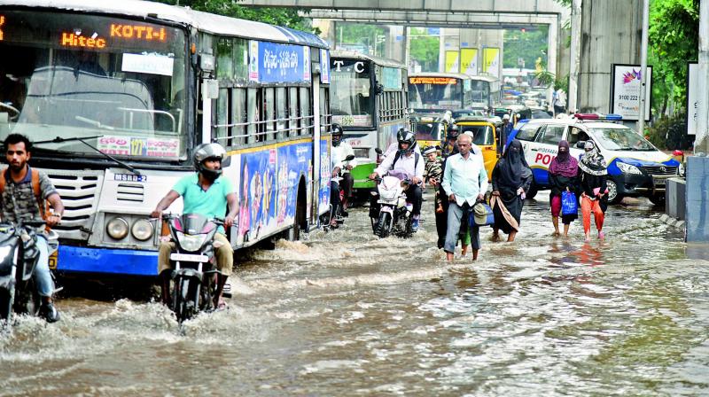 Motorists and pedestrians wade through the waterlogged road opposite the police control room after sudden rains lashed the city on Tuesday. (Photo: S. Surender Reddy) Motorists and pedestrians wade through the waterlogged road opposite the police control room after sudden rains lashed the city on Tuesday. (Photo: S. Surender Reddy)