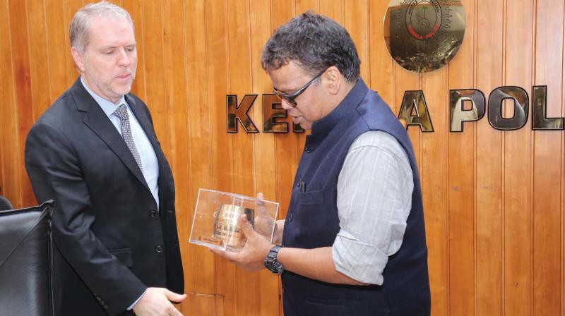 DGP Loknath Behra presents a memento to Interpol officer Guillermo Galarza, who was on a visit at Cyberdome in Thiruvananthapuram on Monday. DGP Loknath Behra presents a memento to Interpol officer Guillermo Galarza, who was on a visit at Cyberdome in Thiruvananthapuram on Monday.