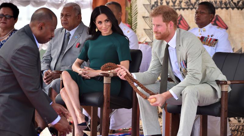 Britain's Prince Harry (R) receives a whale tooth necklace as his wife Meghan, Duchess of Sussex (C) looks on during a farewell ceremony at Nadi airport on October 25, 2018.(Photo: AFP) Britain's Prince Harry (R) receives a whale tooth necklace as his wife Meghan, Duchess of Sussex (C) looks on during a farewell ceremony at Nadi airport on October 25, 2018.(Photo: AFP)