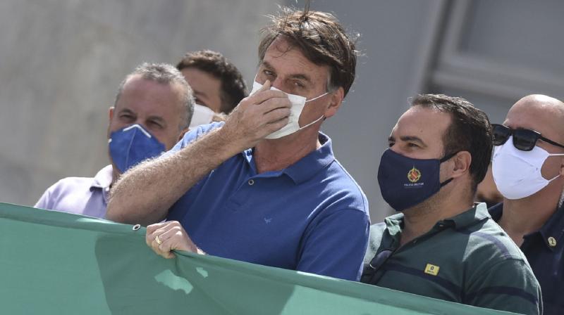 In this May 17, 2020 file photo of Brazil's president Jair Bolsonaro, wearing a protective face mask as a precaution against the spread of the new coronavirus. A profanity-laced video showing Bolsonaro expressing frustration at his inability to get information from police and vowing to change Cabinet ministers if needed to protect his family was released on Friday, May 22, 2020, at the order of a Supreme Court justice in a new blow to a president whose popularity has been sagging. (AP) In this May 17, 2020 file photo of Brazil's president Jair Bolsonaro, wearing a protective face mask as a precaution against the spread of the new coronavirus. A profanity-laced video showing Bolsonaro expressing frustration at his inability to get information from police and vowing to change Cabinet ministers if needed to protect his family was released on Friday, May 22, 2020, at the order of a Supreme Court justice in a new blow to a president whose popularity has been sagging. (AP)