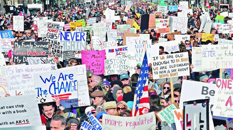 People hold signs on Pennsylvania Avenue at the “March for Our Lives” rally, the biggest protest for gun control in a generation, on Saturday in Washington. — AP People hold signs on Pennsylvania Avenue at the “March for Our Lives” rally, the biggest protest for gun control in a generation, on Saturday in Washington. — AP