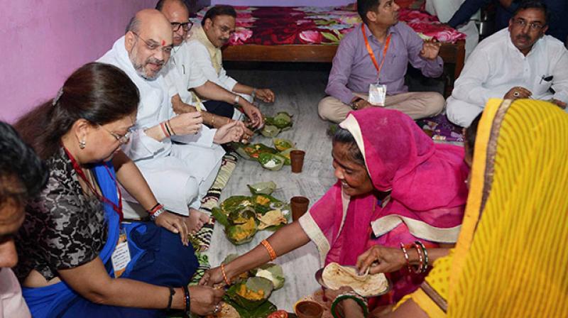 BJP President Amit Shah with Rajasthan Chief Minister Vasundhara Raje having lunch at Dalit Family during his three day visit in Jaipur on Sunday. (Photo: PTI) BJP President Amit Shah with Rajasthan Chief Minister Vasundhara Raje having lunch at Dalit Family during his three day visit in Jaipur on Sunday. (Photo: PTI)