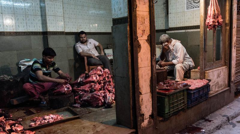 Indian butchers work in their shop as they prepare buffalo meat for sale in New Delhi. (AFP Photo) Indian butchers work in their shop as they prepare buffalo meat for sale in New Delhi. (AFP Photo)
