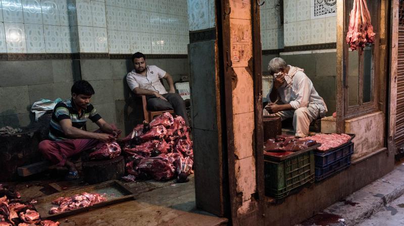 Indian butchers work in their shop as they prepare buffalo meat for sale in New Delhi. (AFP Photo)