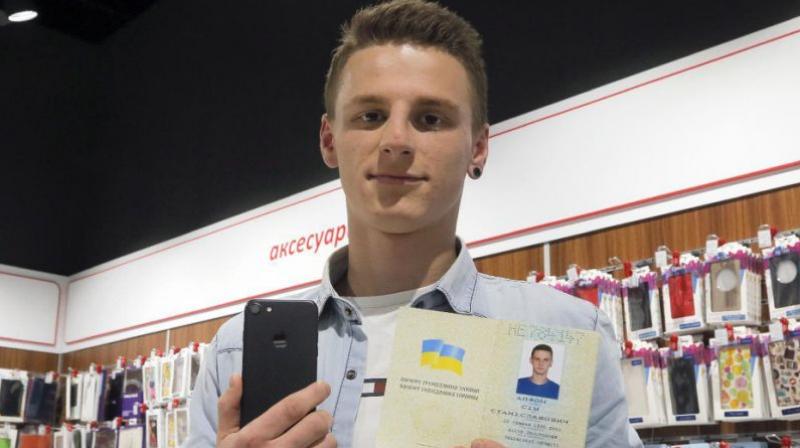 A young man shows his passport giving his name as iPhone Sim (seven), and a new iPhone 7 in an electronics shop in Kiev, Ukraine, Friday, Oct. 28, 2016. (Photo: AP) A young man shows his passport giving his name as iPhone Sim (seven), and a new iPhone 7 in an electronics shop in Kiev, Ukraine, Friday, Oct. 28, 2016. (Photo: AP)