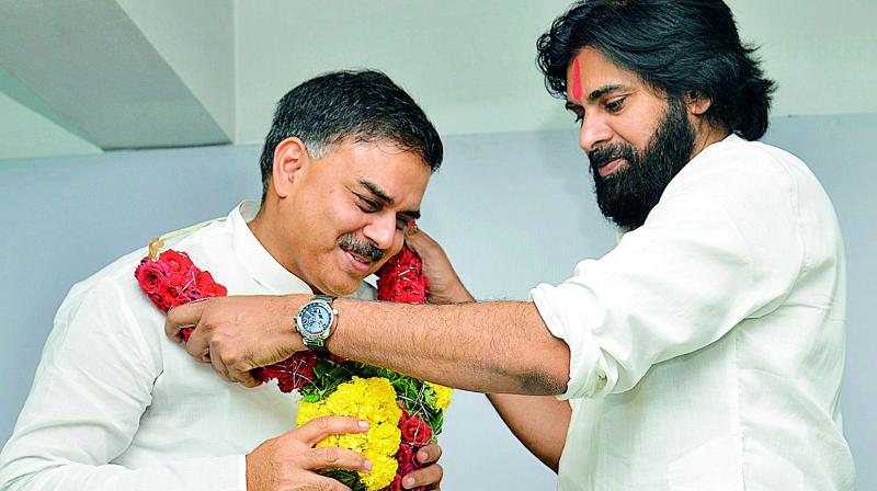 Jana Sena chief Pawan Kalyan puts a garland on Congress leader Nadendla Manohar to welcome him into the party in Vijayawada on Friday. (DC) Jana Sena chief Pawan Kalyan puts a garland on Congress leader Nadendla Manohar to welcome him into the party in Vijayawada on Friday. (DC)