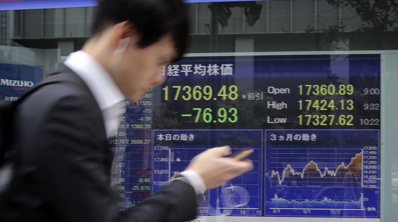 A man walks by an electronic stock board of a securities firm in Tokyo, A man walks by an electronic stock board of a securities firm in Tokyo,
