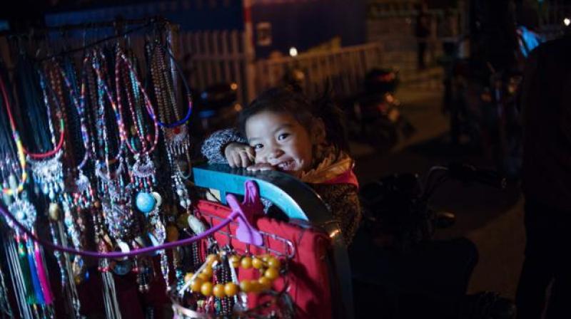 A girl plays on a souvenir vendors cart in the regional capital Lhasa, in China's Tibet Autonomous Region. The traditional teahouses and fashion boutiques of Bayi are the among the liveliest districts of Lhasa, and owned and patronised by both Tibetans and Han Chinese. But some say increasing prosperity is just Beijing buying peace. (Photo: AFP) A girl plays on a souvenir vendors cart in the regional capital Lhasa, in China's Tibet Autonomous Region. The traditional teahouses and fashion boutiques of Bayi are the among the liveliest districts of Lhasa, and owned and patronised by both Tibetans and Han Chinese. But some say increasing prosperity is just Beijing buying peace. (Photo: AFP)