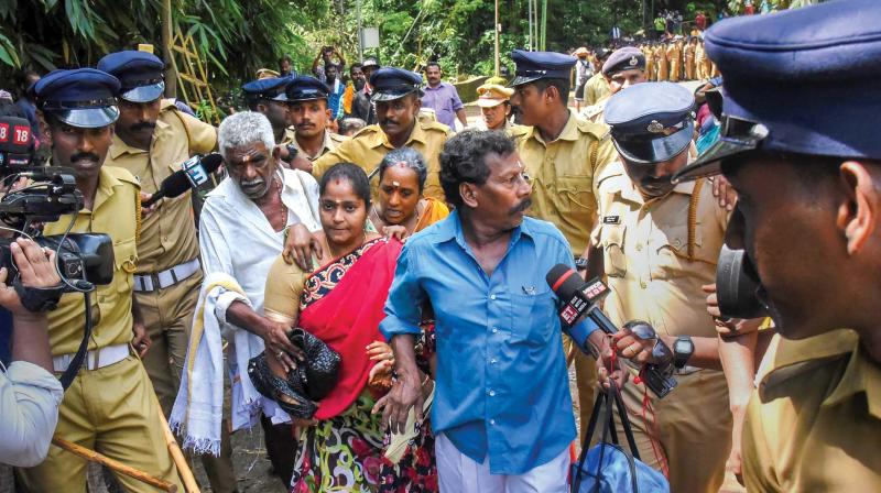 Police escorts Madhavi (of Andhra Pradesh) and her family members after she was heckled by protesters while proceeding to Sabarimala temple on its opening day on Wednesday. –PTI Police escorts Madhavi (of Andhra Pradesh) and her family members after she was heckled by protesters while proceeding to Sabarimala temple on its opening day on Wednesday. –PTI