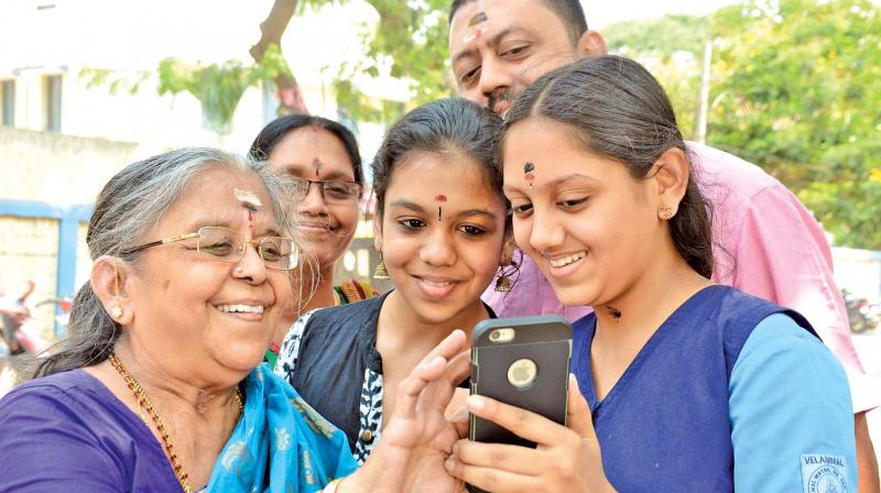 A student shows her results to her grandmother on her phone while the rest of the family looks on in Mogappair on Friday. (Photo: DC) A student shows her results to her grandmother on her phone while the rest of the family looks on in Mogappair on Friday. (Photo: DC)