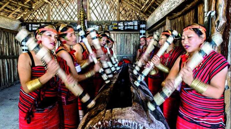 Tribal women play log drum during the Hornbill Festival. Kisama, Nagaland, India. Tribal women play log drum during the Hornbill Festival. Kisama, Nagaland, India.