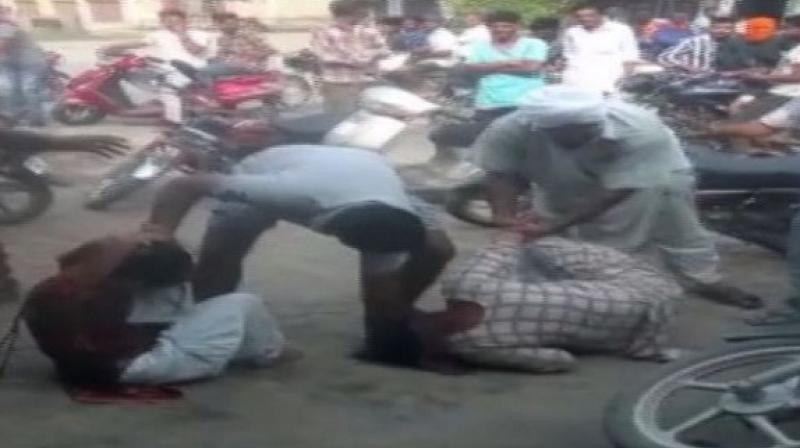 A video of the incident, that has now gone viral on social media, shows a group of men brutally thrashing two women and hurling abuses at them. (Photo: ANI) A video of the incident, that has now gone viral on social media, shows a group of men brutally thrashing two women and hurling abuses at them. (Photo: ANI)