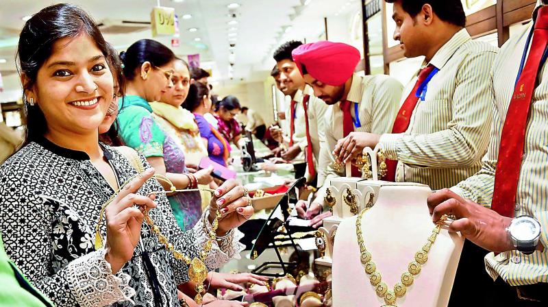A woman tries a gold necklace in a shop on the occasion of Akshaya Tritiya in New Delhi on Friday.(Photo: PTI) A woman tries a gold necklace in a shop on the occasion of Akshaya Tritiya in New Delhi on Friday.(Photo: PTI)