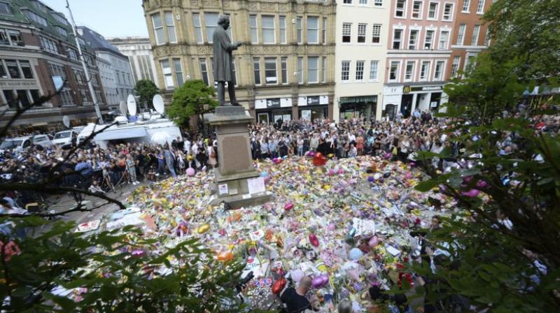 People hold a minute of silence in a square in central Manchester (Photo: AP) People hold a minute of silence in a square in central Manchester (Photo: AP)