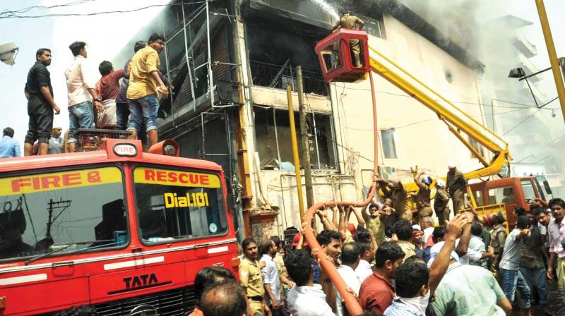 Firemen fight the blaze at a readymade unit at SM Street in Kozhikode. (Inset) Ill-maintained fire safety system at a shop at SM Street. Firemen fight the blaze at a readymade unit at SM Street in Kozhikode. (Inset) Ill-maintained fire safety system at a shop at SM Street.