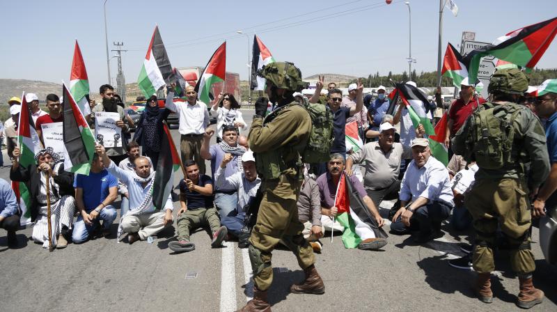 Palestinians protestors hold national flags during protest in solidarity with Palestinian prisoners on hunger strike in Israeli jails. (Photo: AP) Palestinians protestors hold national flags during protest in solidarity with Palestinian prisoners on hunger strike in Israeli jails. (Photo: AP)