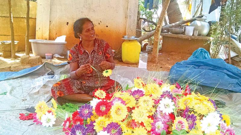 A Narikuravar woman at Adigathur beads the flowers to make a vase A Narikuravar woman at Adigathur beads the flowers to make a vase
