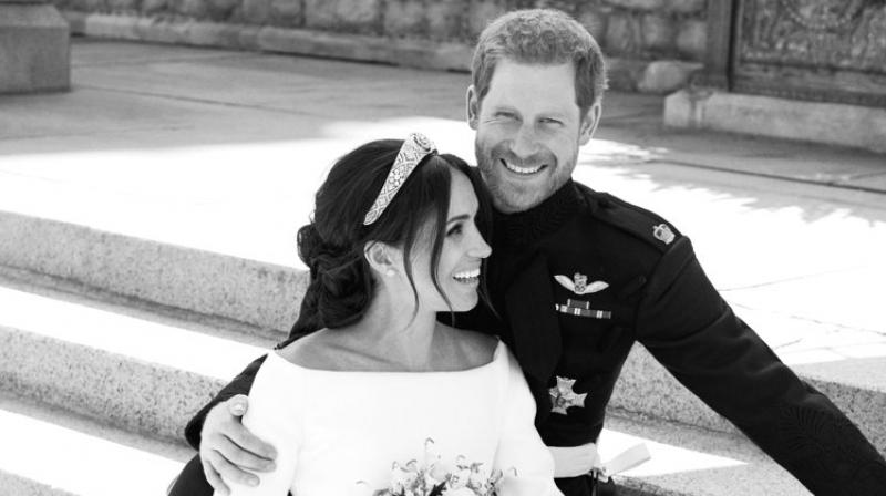 One of the most striking image shows the US actor sitting between Harry's legs on the east terrace of Windsor Castle as the prince looks smiling at the camera while his new bride laughs at someone to their left. (Photo: AP) One of the most striking image shows the US actor sitting between Harry's legs on the east terrace of Windsor Castle as the prince looks smiling at the camera while his new bride laughs at someone to their left. (Photo: AP)