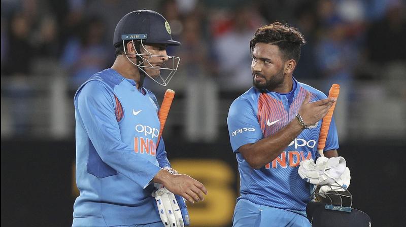 Rishabh Pant (R) keenly listens to MS Dhoni on their walk back to the pavillion after winning the Twenty/20 game against New Zealand at Eden Park in Auckland, New Zealand. AP Photo