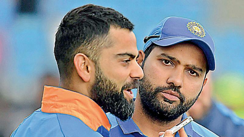 Virat Kohli and Rohit Sharma discuss strategy during a the World Cup game at Headingley in Leeds, northern England. AFP Photo