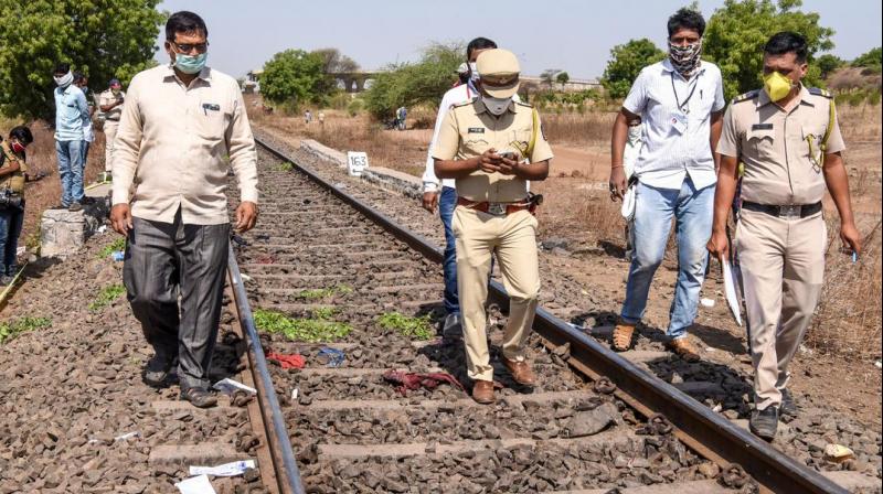 Police personnel along with officials walk on a rail track as they check the site following a train accident in Aurangabad district on Friday.(AFP)