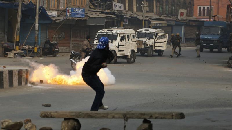 A civilian crosses a road as a tear gas shell directed towards protestors explodes near him in Srinagar. (Photo: AP) A civilian crosses a road as a tear gas shell directed towards protestors explodes near him in Srinagar. (Photo: AP)