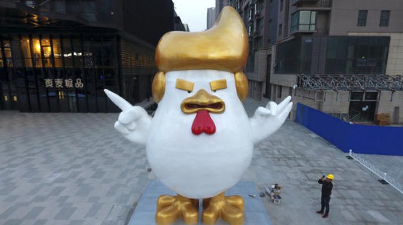 A worker takes a picture of a giant rooster sculpture resembling U.S. President-elect Donald Trump on display outside a shopping mall to celebrate the upcoming Chinese Year of the Rooster in Taiyuan. (Photo: AP) A worker takes a picture of a giant rooster sculpture resembling U.S. President-elect Donald Trump on display outside a shopping mall to celebrate the upcoming Chinese Year of the Rooster in Taiyuan. (Photo: AP)
