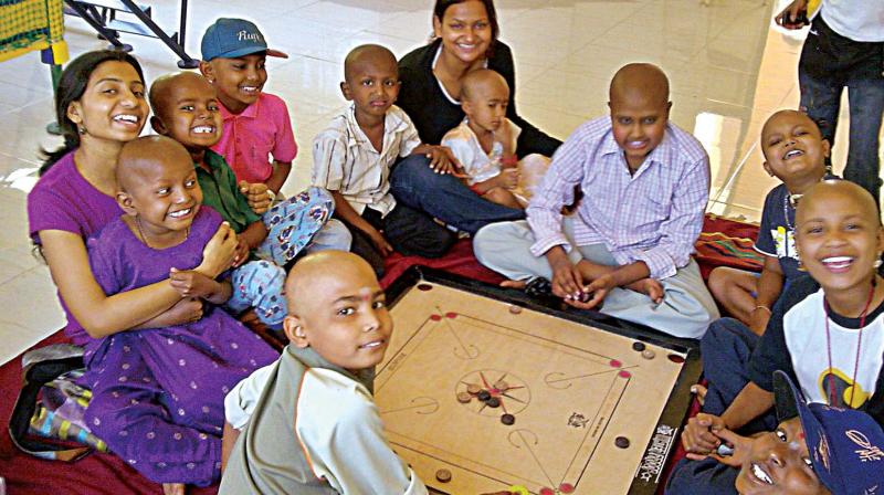 A file photo of volunteers of an NGO with children under treatment for cancer. A file photo of volunteers of an NGO with children under treatment for cancer.