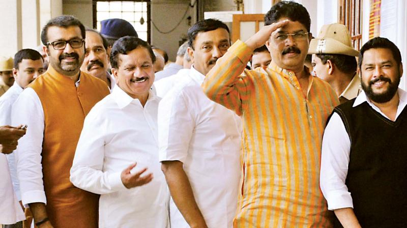 Legislators N.A. Haris of the Congress, and K.G. Bopaiah and R. Ashok of the BJP wait in a queue to cast their votes in Bengaluru on Monday. (Photo: DC) Legislators N.A. Haris of the Congress, and K.G. Bopaiah and R. Ashok of the BJP wait in a queue to cast their votes in Bengaluru on Monday. (Photo: DC)