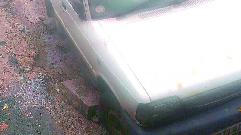 The Maruti 800 car stuck in a trench dug up by L&T in Sainikpuri limits. The Maruti 800 car stuck in a trench dug up by L&T in Sainikpuri limits.