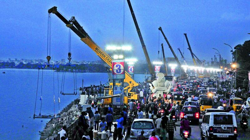 Cranes set up along the Hussainsagar to carry out immersions. Over 10 lakh people are expected to join the processions. (Photo: DC) Cranes set up along the Hussainsagar to carry out immersions. Over 10 lakh people are expected to join the processions. (Photo: DC)