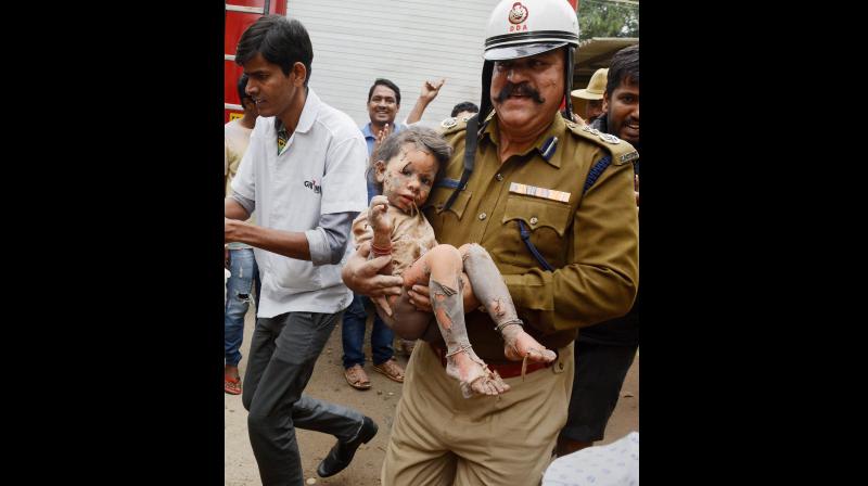 A fireman carries an injured rescued after a building collapsed due to a suspected cylinder blast at Ejipura area in Bengaluru on Monday. (Photo: PTI) A fireman carries an injured rescued after a building collapsed due to a suspected cylinder blast at Ejipura area in Bengaluru on Monday. (Photo: PTI)