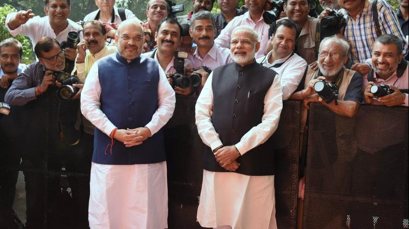 Prime Minister Narendra Modi with BJP President Amit Shah poses for a group picture with photo journalists during the Deepawali Mangal Milan programme at BJP headquarters in New Delhi on Saturday. (Photo: PTI) Prime Minister Narendra Modi with BJP President Amit Shah poses for a group picture with photo journalists during the Deepawali Mangal Milan programme at BJP headquarters in New Delhi on Saturday. (Photo: PTI)
