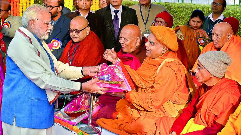 Prime Minister Narendra Modi presents gifts to Buddhist monks in New Delhi on Wednesday. (Photo: PTI) Prime Minister Narendra Modi presents gifts to Buddhist monks in New Delhi on Wednesday. (Photo: PTI)