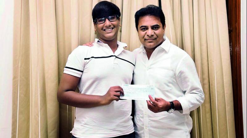 Sai Vishruth Reddy, a class X student of Future Kids International School, hands over a cheque for `50,000 to Minister for IT & Municipal Administration K.T. Rama Rao on Tuesday. (Photo: DC)