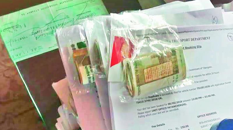 Applications found lying on the table at the RTO office in Patancheru with bundles of cash in a plastic cover pinned to the. (Photo: DC) Applications found lying on the table at the RTO office in Patancheru with bundles of cash in a plastic cover pinned to the. (Photo: DC)
