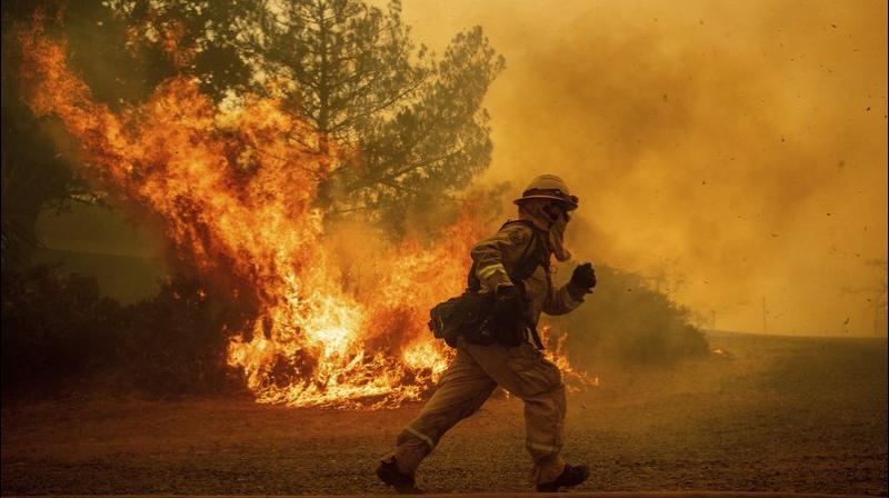 A firefighter runs while trying to save a home as a wildfire tears through Lakeport, Calif. The residence eventually burned. (Photo: AP) A firefighter runs while trying to save a home as a wildfire tears through Lakeport, Calif. The residence eventually burned. (Photo: AP)