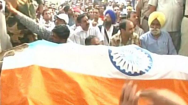 The mortal remains of BSF Head Constable Sushil Kumar were consigned to flames with full military honours at his village in Haryana on Tuesday. (Photo: ANI/Twitter) The mortal remains of BSF Head Constable Sushil Kumar were consigned to flames with full military honours at his village in Haryana on Tuesday. (Photo: ANI/Twitter)