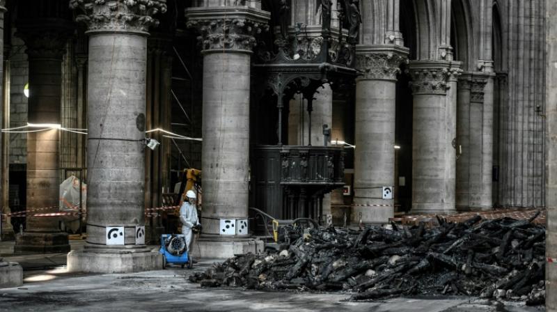 On Wednesday, instead of crowds, only a few dozen specialist workers wearing white protective overalls, hard hats and masks could be seen carrying out painstaking work to make the building safe. (Photo: AFP) On Wednesday, instead of crowds, only a few dozen specialist workers wearing white protective overalls, hard hats and masks could be seen carrying out painstaking work to make the building safe. (Photo: AFP)